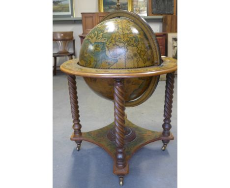 A Victorian style walnut drinks cabinet in the form of a revolving library globe on rope twist legs and platform base with ca