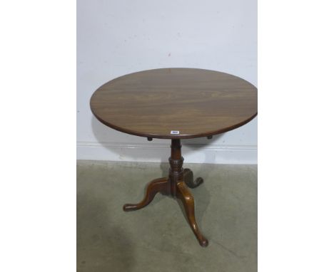 A Georgian mahogany circular flip top table on turned support and tripod base with one piece top - 74cm x 81cm diameter