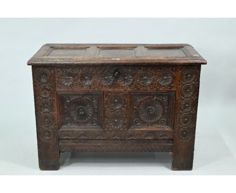 A 17th century oak coffer, the triple panel top enclosing a fitted candle box with 'secret' drawer within, the base planks wi
