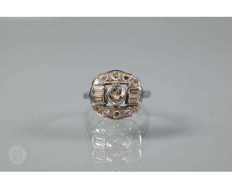 An Art Deco style diamond cluster ring, the central round brilliant cut diamond with two baguette diamonds to each side, and 