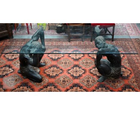 An mid 20th century Italian glass top twin blackamoor dining table in the manner of Chelini, the patinated and parcel-gilt br