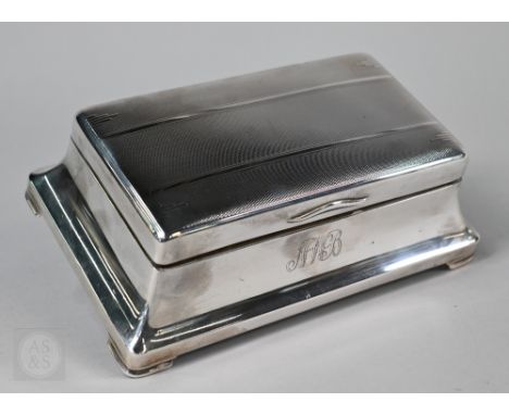 An Art Deco silver cigarette box with engine-turned top and flared base, Beddoes &amp; Co. Ltd., Birmingham 1936, 20cm wide&n