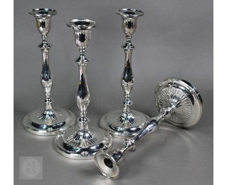 A set of four George III loaded silver baluster candlesticks with detachable grease-pans and foliate fluting, turned wood und