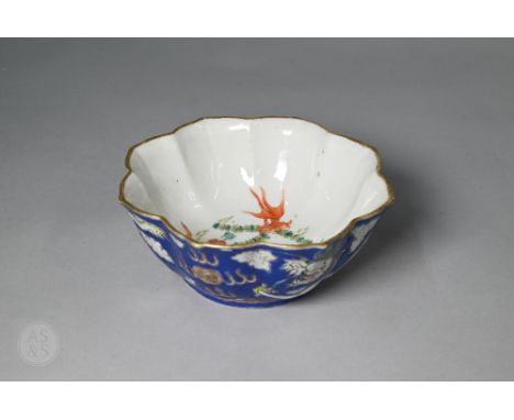 A 19th century Chinese lotus shaped bowl, the exterior decorated in white and blue enamels with dragons and flaming pearls an