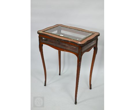 A French brass mounted kingwood vitrine table, the bevel edge panelled hinged top over all-round glazed in sides, raised on s