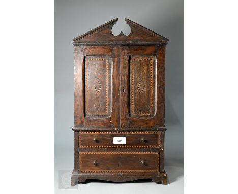 A miniature boxwood inlaid oak cabinet in the form of a linen press, 19th century, the broken arch pediment over a pair of pa