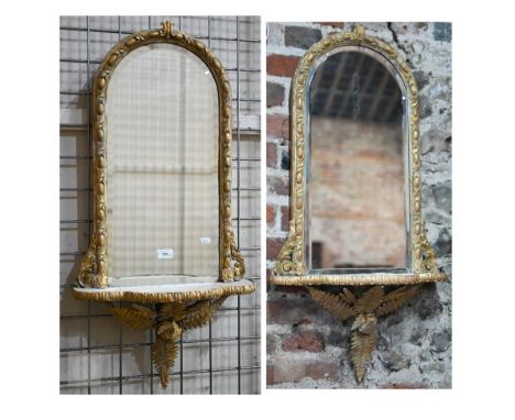 A companion pair of Victorian giltwood and gesso arched top mirror backed wall brackets, the bevelled plates over a serpentin