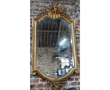 A 19th century continental giltwood framed mirror, surmounted by a flute playing cherub, in the baroque style with bevel edge