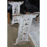 A cast iron trestle table base with aesthetic movement decoration, together with four folding wooden