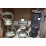 Two large bell weights, together with a miner's lamp