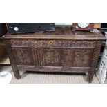 An early 18th century oak coffer, with hinge lid & three panels to the front, richly carved, 122cm w