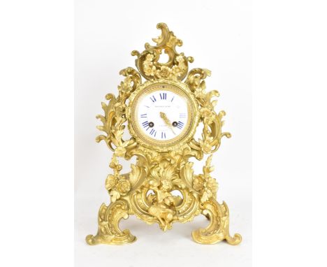 A late 19th century French gilt bronze mantle clock, the ornate case cast with C-scrolls, vines and flower heads with a seate