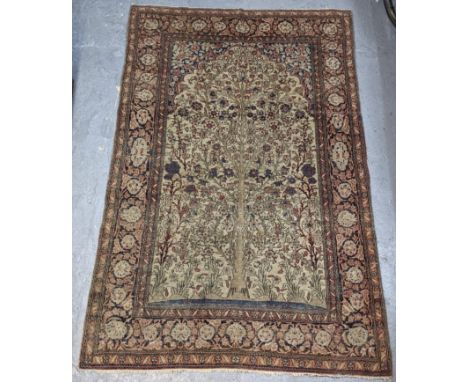 A Persian hand woven woollen rug, the field decorated with a tree of life, surrounded by multi-guard borders with repeating f