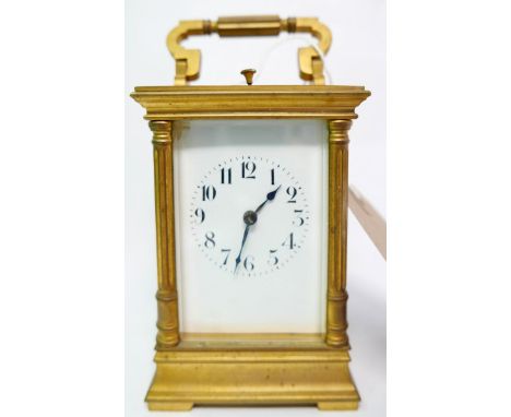 A 20th century brass repeating carriage clock, with white enameled dial and Arabic numerals, chiming gong and bevelled glass 