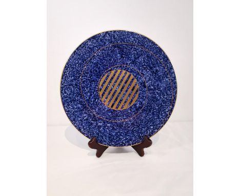 Peter Ting - a Tingware ceramic circular  decorative plate with blue dappled ground and gold spiral. Makers stamp, signed to 