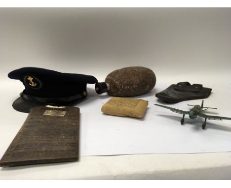 A box of military items to include gas mask eye shields, field dressing, a peaked Navy cap and an animal fur flask