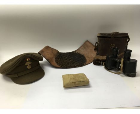 A box of military items including a cased set of binoculars marked "M.Riddle" to the interior, a peaked cap, a leather belt a