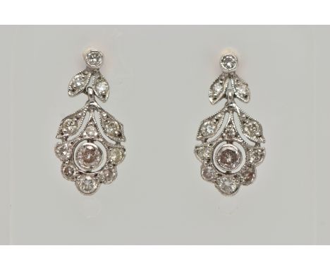 A PAIR OF WHITE METAL, DIAMOND DROP EARRINGS, each earring set with a central round brilliant cut diamond in a milgrain setti