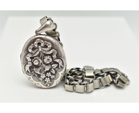 A WHITE METAL OVAL LOCKET AND BOOK CHAIN, the locket decorated with a floral and bow pattern, opens to reveal a lock of blond