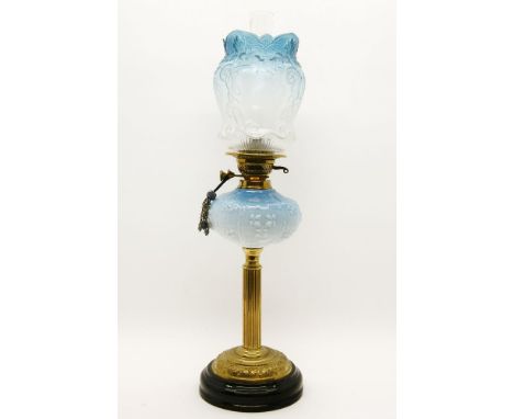 An Edwardian brass column oil lamp, with blue glass reservoir and shade with frogs playing guitars, 70cm high (top of chimney