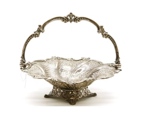 A Victorian pierced silver bread basket, of lobed form, with cast swing handle, shaped rim and on pierced scrolling feet, 28c