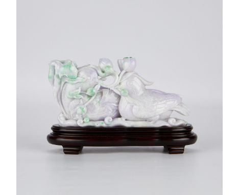 Chinese jade carving of a pair of ducks bearing flowers in their beaks. Carved from a pale lavender jade, with the green incl