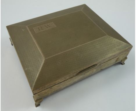 A silver cigarette box, Birmingham 1931, with engine turned hinged lid, raised on splay feet, 14 x 17 x 6 cm, initialled, ced