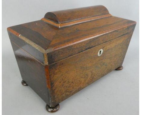 An early 19th century rosewood and mahogany tea caddy, the hinged lid opening to reveal two compartments and glass mixing bow