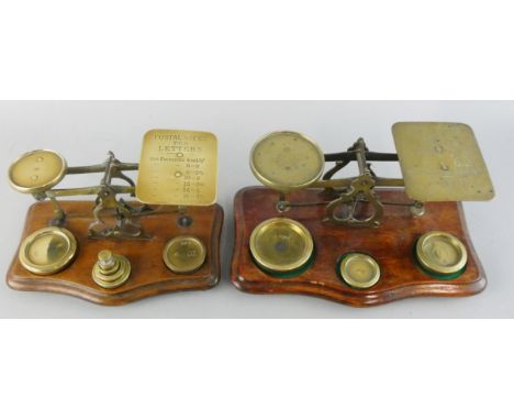 A Victorian set of brass and mahogany postal scales, the plate inscribed with weights and prices, and another similar (2).
