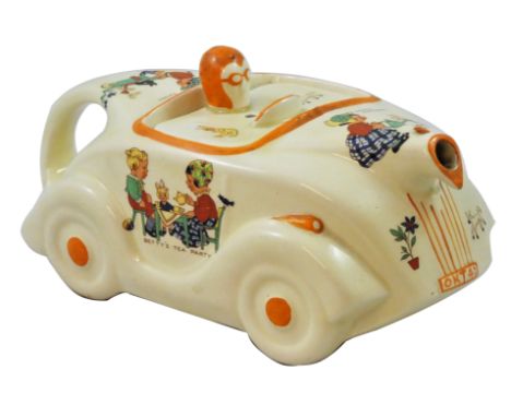 An unusual racing car teapot by James Sadler, with transfer printed nursery scenes designed by Mabel Lucie Attwell, stamped M