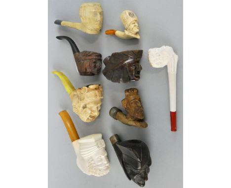 A Meerschaum pipe with amber stem, the bowl depicting a Turk's head, 16 cm, another depicting a Bacchus, a smaller example de