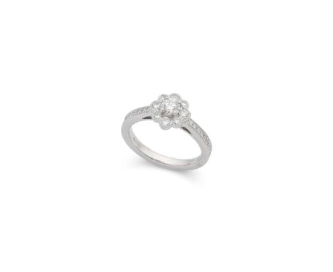  † A platinum diamond cluster ring  Claw-set with a cluster of round brilliant-cut diamonds, each shoulder set with smaller r