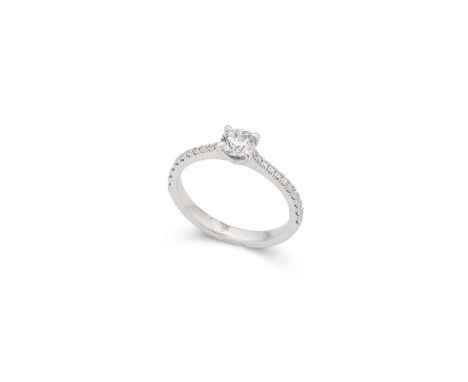  † A platinum diamond ring  Claw-set with a round brilliant-cut diamond, each shoulder set with smaller round brilliant-cut d