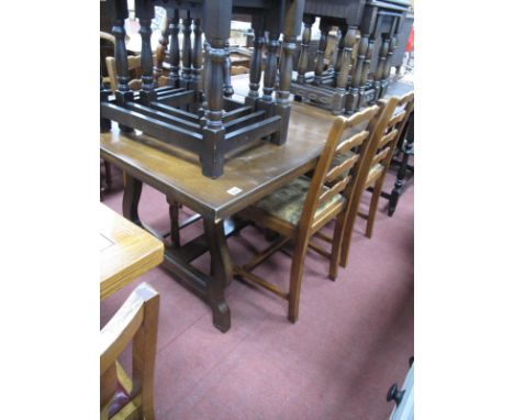 Four Ladder Back Chairs; together with an oak draw leaf dining table, on shaped supports..