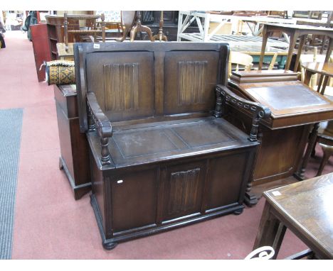 An Oak Monks Bench, with linen fold fascia, on bun feet, 95cm wide.