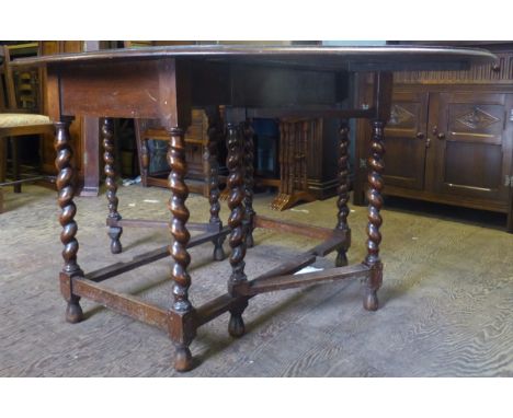 Dark oak drop leaf/gate leg dining table with barley twist supports, 150cm when extended. 