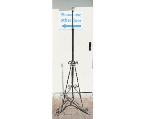 Three legged wrought iron standard lamp converted to electric. height to top of fitting 153cm 
