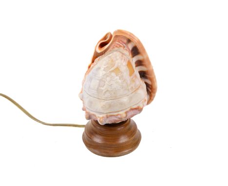 A 20th century cameo carved conch table lamp. The lamp having a conch shell shade carved with mythological or allegorical dep