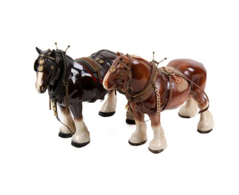 Two Beswick ceramic shire horses. One glazed in brown, the other in black, both wearing saddles and reins, H25cm