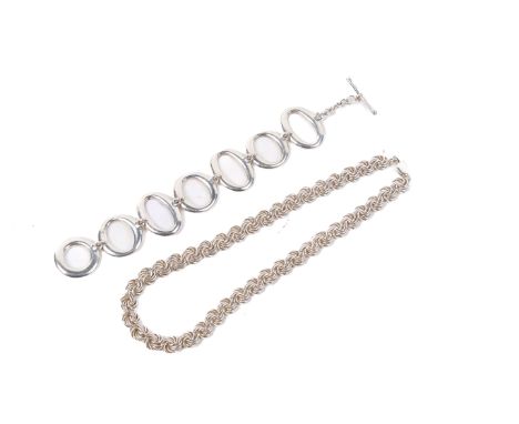 Two contemporary silver jewellery pieces. Comprising a woven chain necklace, length 38cm, and a bangle of pierced circles. Gr