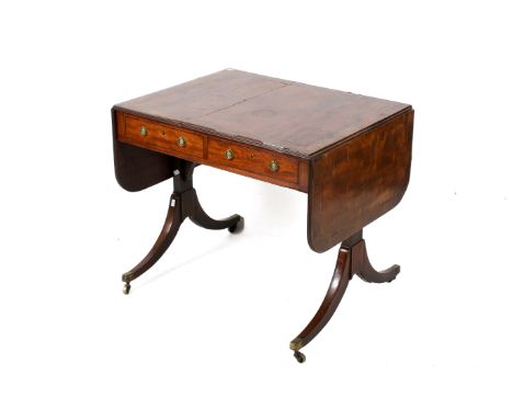 A Regency mahogany and inlaid satinwood sofa table. The rectangular drop leaf top with curved corners, with two frieze drawer