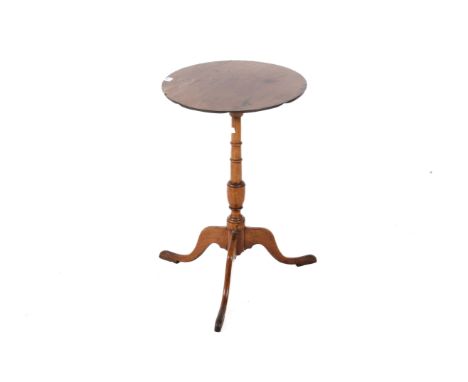 A mahogany Georgian style tilt-top table. Having a round top with a carved baluster pedestal, tripod base terminating at pad 
