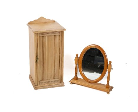 A vintage pine pot cupboard and a contemporary dressing table mirror. The cupboard having a panelled door opening to reveal a