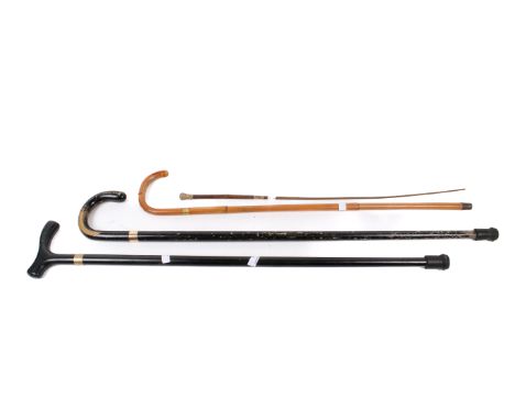 Three walking sticks and a riding crop. The riding crop having a snakeskin handle and yellow metal collar engraved 'CRV Sept.