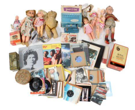 An assortment of vintage collectables. Including dolls, vinyl records, tins and a toy typewriter, etc.
