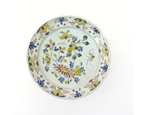 A large Bristol delftware charger  c.1740, painted in polychrome enamels with a flying insect above sprays of Oriental flower