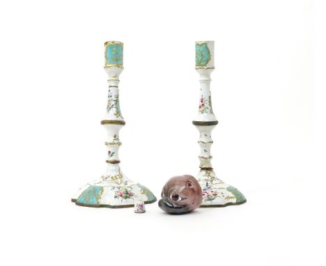 A pair of enamel candlesticks  c.1770, painted with flowers and with raised gilt foliate scrolls on green panels, an enamel b