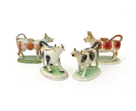 Four cow creamers and covers 19th/20th century, standing on oval bases, two with heads uplifted and lowing, decorated with sp