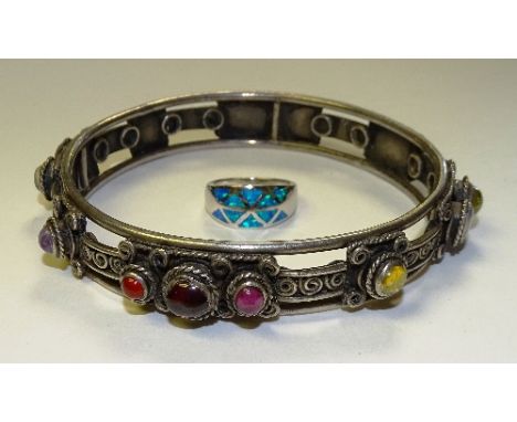 A silver and opal ring, stamped 925 to underside, ring size N, together with a large white metal Eastern bangle set with semi