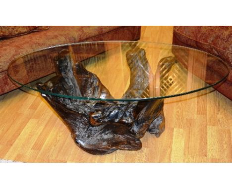 A naturalistic tree trunk coffee table, with glass top, 44cm high x 115cm wide